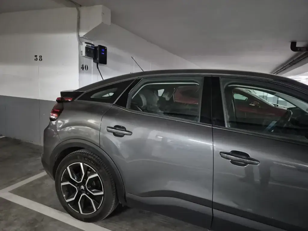 Vehículo eléctrico Citroën conectado a punto de recarga en garaje comunitario en Madrid